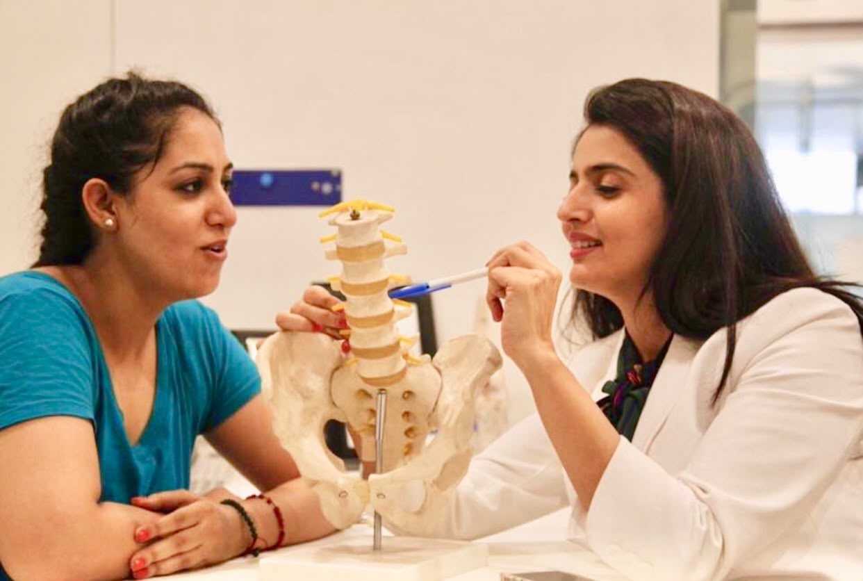 Dr. Vandana teaching with a spine and pelvis anatomical model